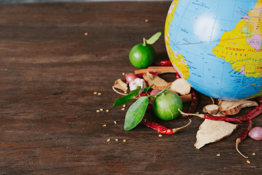 A globe surrounded by an array of spices, symbolizing the universal love for flavorful food.